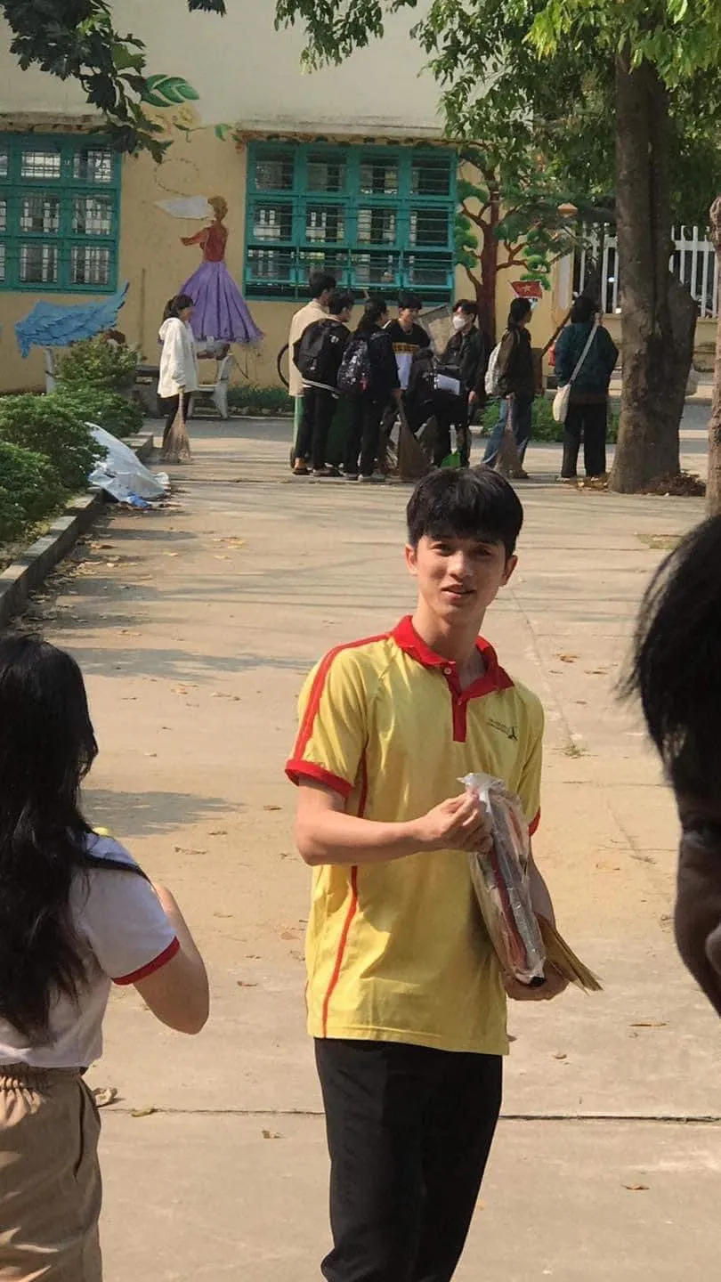 Ảnh trai đẹp 2006 che mặt có một cậu bé đi bộ trên vỉa hè với cuốn sách