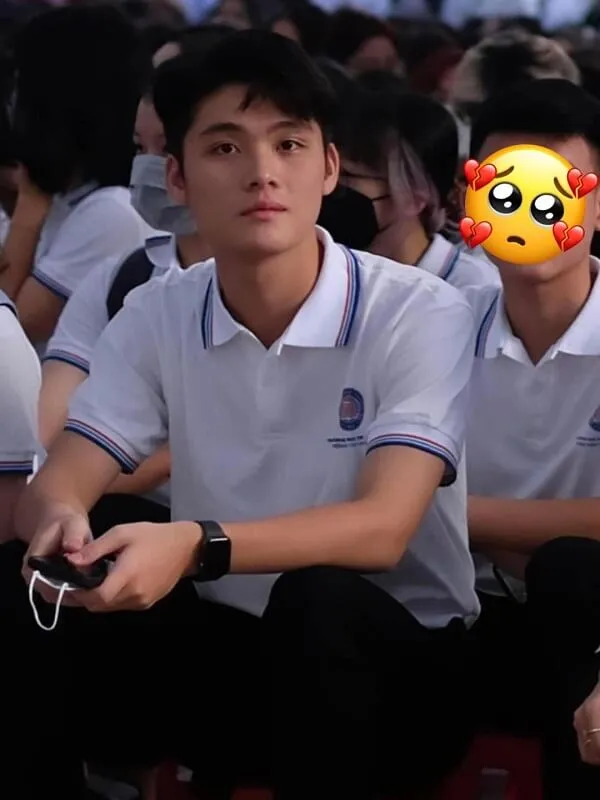 Ảnh trai đẹp 2006 cậu bé mặc áo sơ mi trắng với khuôn mặt tình cảm ngồi trước một nhóm người