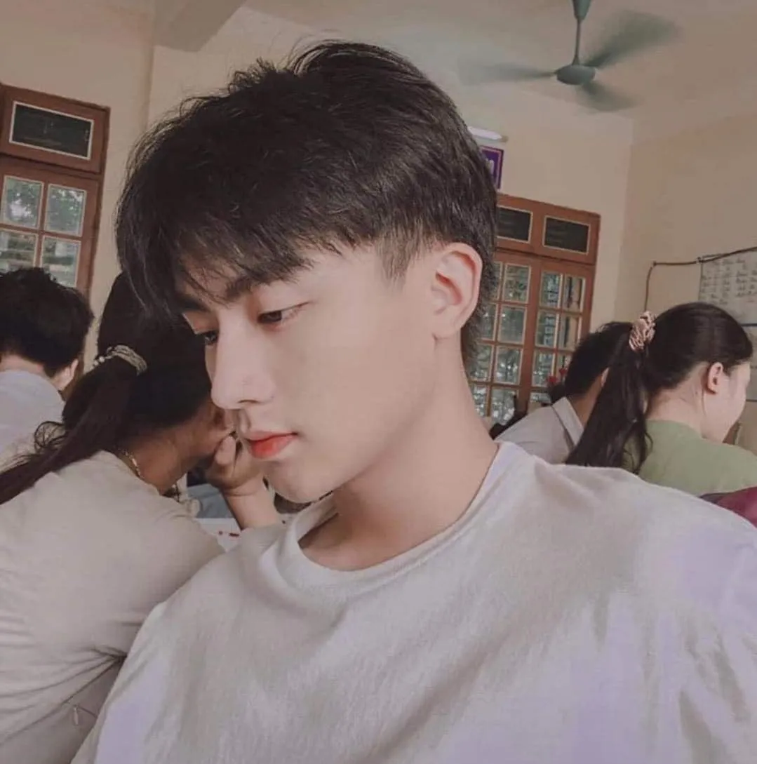 Hình ảnh trai đẹp 2006 thanh niên mặc áo trắng ngồi trước một nhóm người