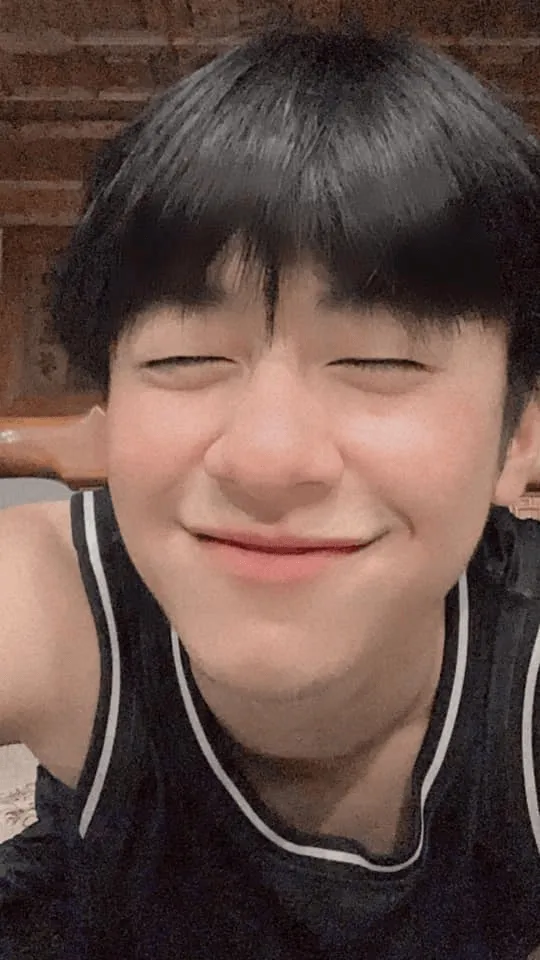Ảnh trai đẹp cute có một chàng trẻ ngồi trên giường với đôi mắt nhắm