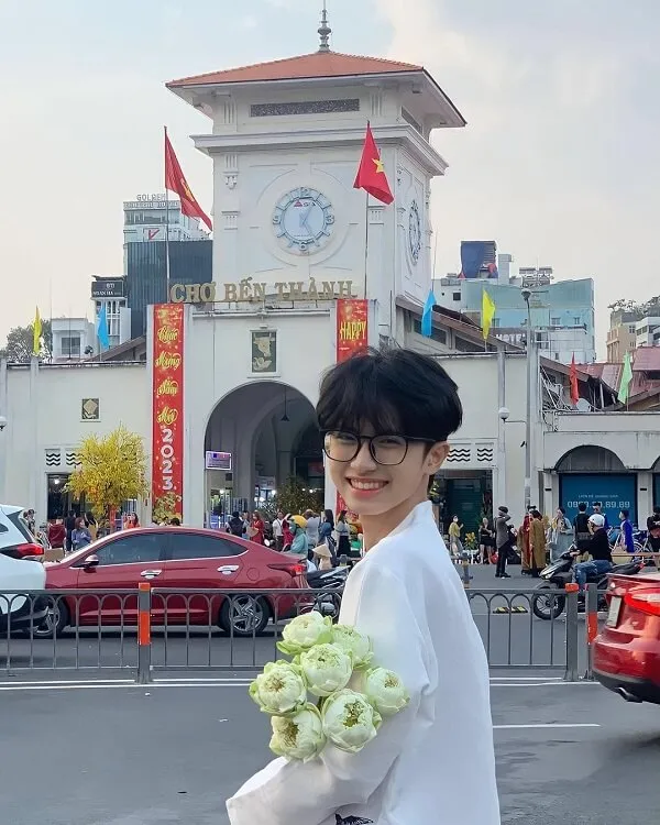 Ảnh trai đẹp học sinh có một người phụ nữ đang cầm bó hoa trước tòa nhà