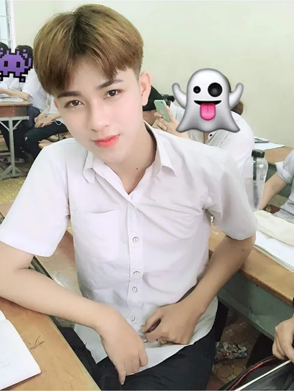 Ảnh trai đẹp học sinh có một cậu bé đang ngồi bàn làm việc với máy tính xách tay
