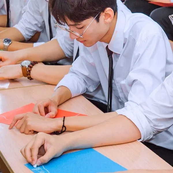 Ảnh trai đẹp học sinh có một người đàn ông đang ngồi bàn làm việc trên cái gì đó