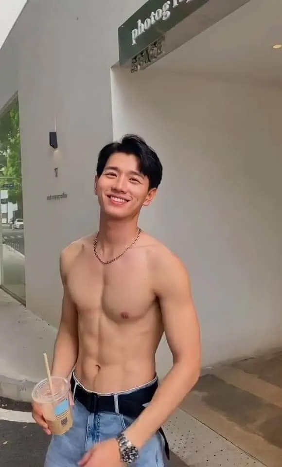 Ảnh trai đẹp múi có một chàng trẻ không áo cầm đồ uống trong tay
