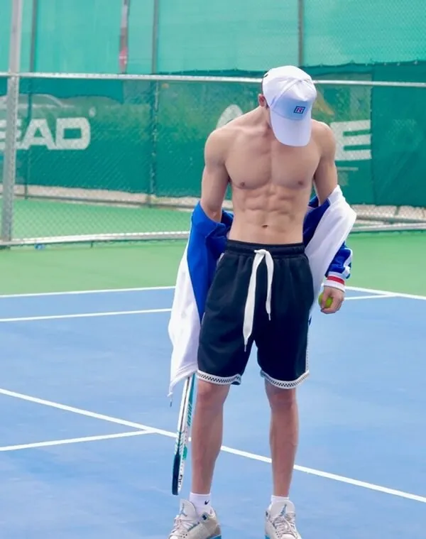 Ảnh trai đẹp múi có một người đàn ông không áo giữ cây vợt tennis trên sân