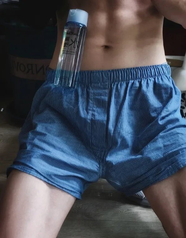Ảnh trai đẹp múi there is shirtless man in blue shorts holding bottle of water