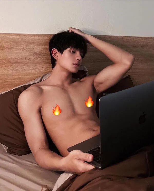 Ảnh trai đẹp ngầu có một người đàn ông nằm trên giường với chiếc máy tính xách tay đùi