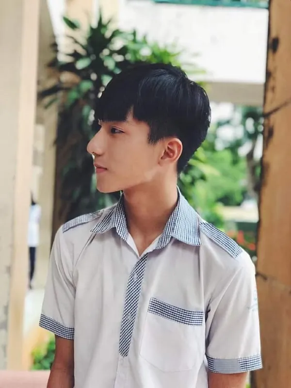 Ảnh trai đẹp học sinh che mặt có một người đàn ông đang đứng trước tòa nhà