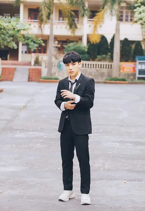 Ảnh trai học sinh người đàn ông châu trong bộ đồ đứng bãi đậu xe nhìn vào điện thoại di động của mình