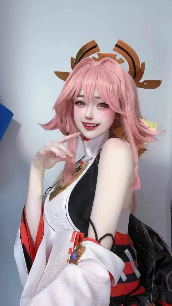 Ảnh yae miko cosplay có một người phụ nữ mái tóc màu hồng tạo dáng cho bức tranh