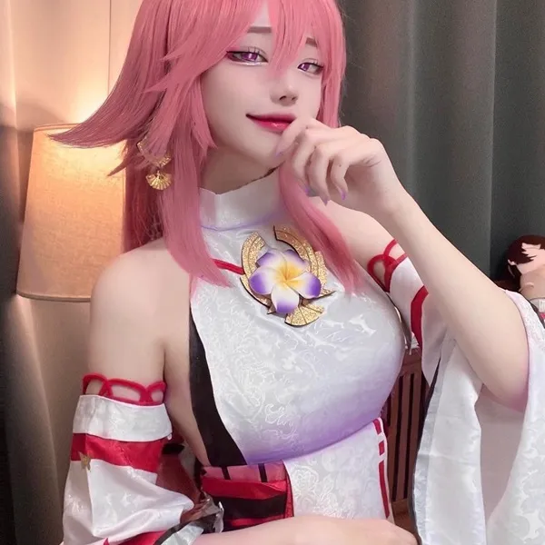Ảnh yae miko cute người phụ nữ tóc vàng với mái màu hồng mặc trang phục trắng và đỏ