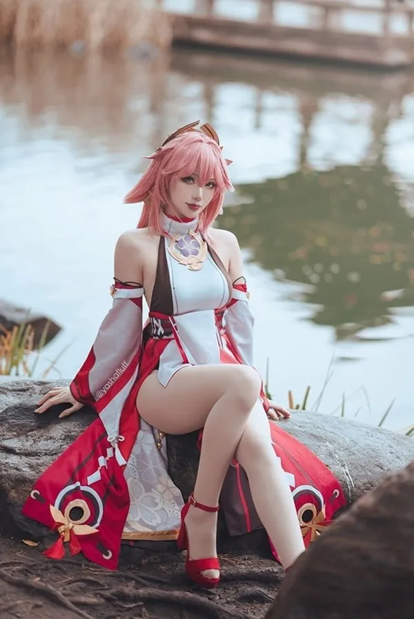 Ảnh yae miko cute có một người phụ nữ đang ngồi trên khúc gỗ bên nước