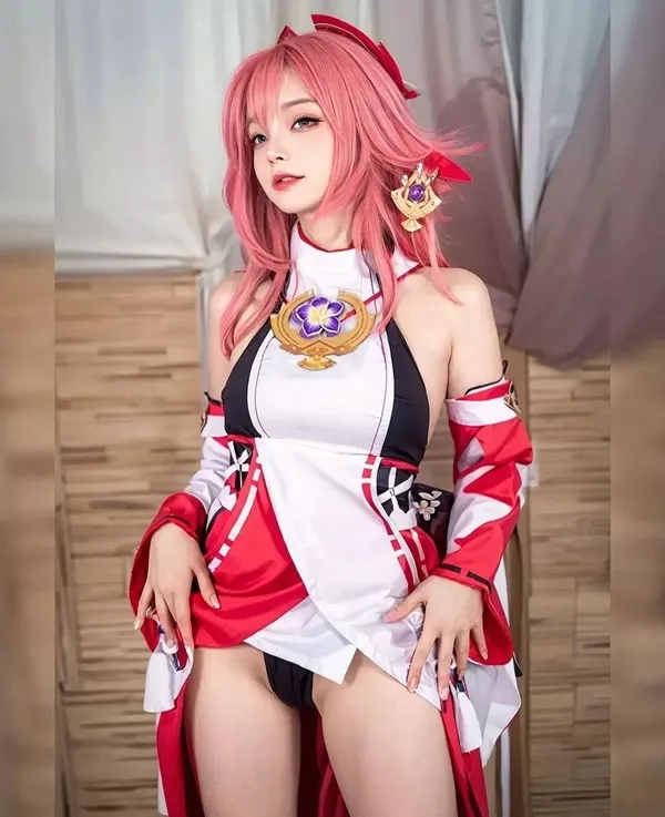 Ảnh yae miko cute có một người phụ nữ mái tóc màu hồng mặc trang phục đỏ và trắng
