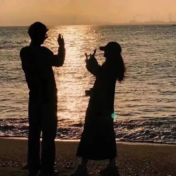 Có một người đàn ông và phụ nữ đang đứng trên bãi biển