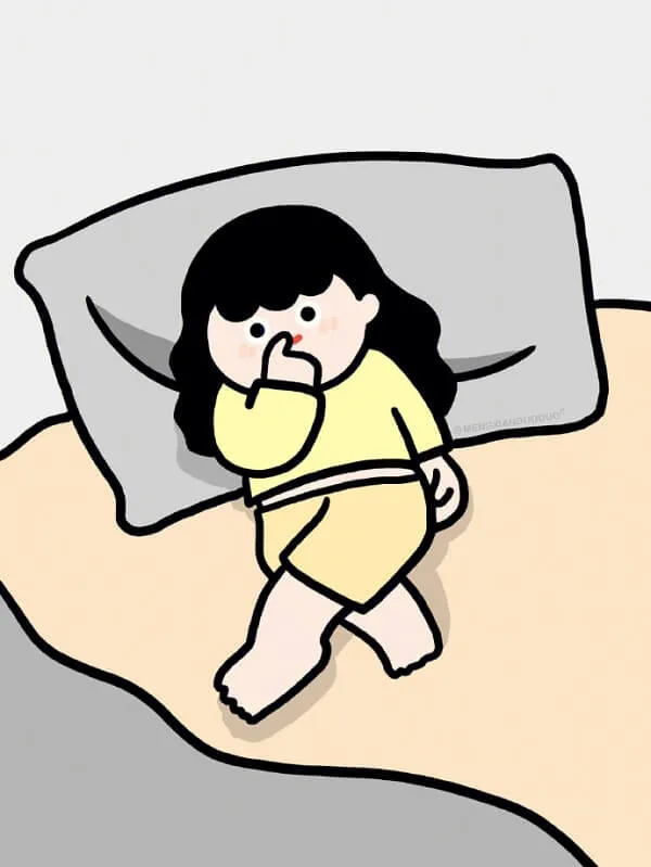Có một cô bé đang nằm trên giường với chiếc gối