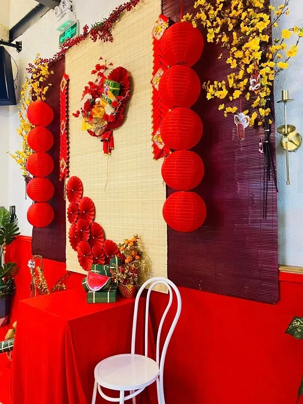 Có một cái bàn màu đỏ với chiếc ghế trắng phía trước bức tường