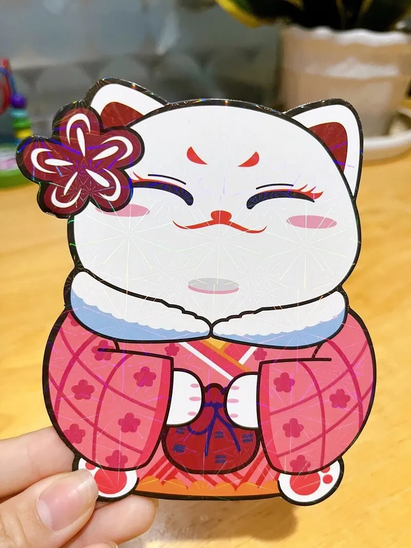 Bao lì xì có một con búp bê giấy của mèo với bông hoa trên tóc