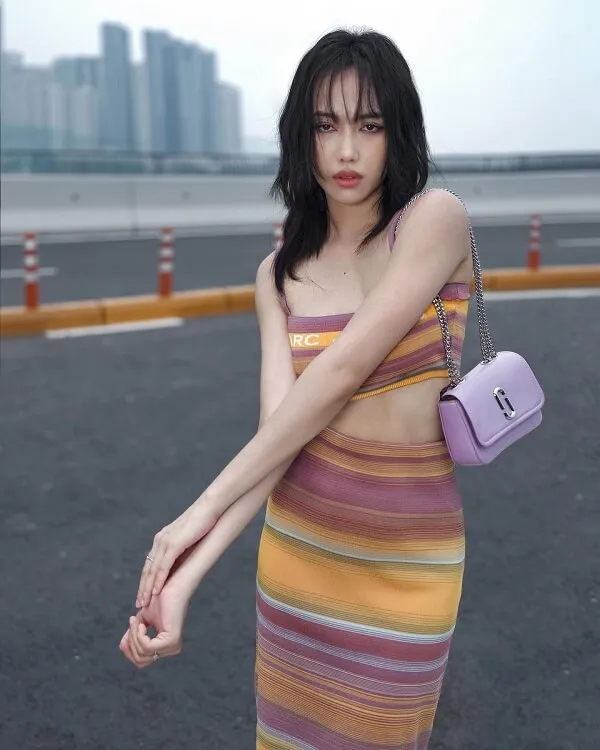 Diệu nhi bikini có một người phụ nữ đang đứng trên đường với chiếc ví