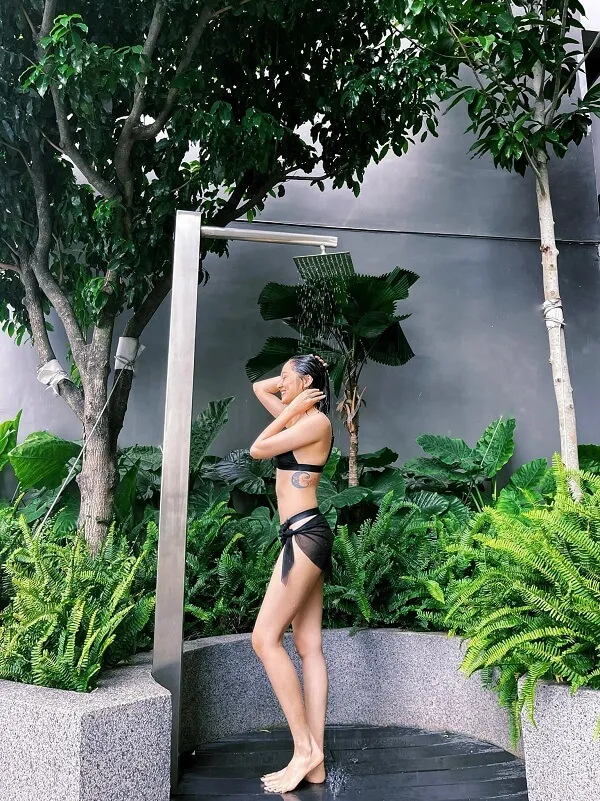 Ca sĩ bảo anh bikini người phụ nữ tóc vàng trong bộ màu đen đứng trước gương
