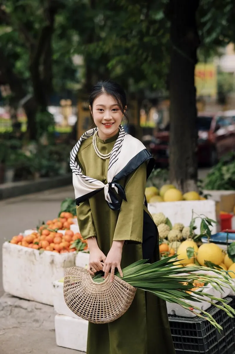Chụp ảnh tết có một người phụ nữ đang đứng trước giá trái cây