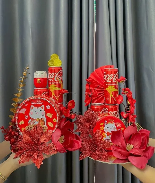 Có hai tay cầm một cái đĩa với đồ trang trí màu đỏ trên đó