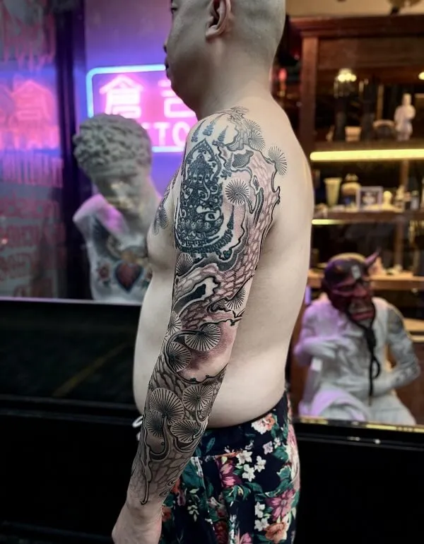 Có một người đàn ông hình xăm trên cánh tay nhìn vào gương