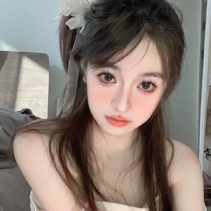 Có một người phụ nữ đang ngồi trên giường với mái tóc