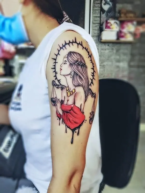 Có một người phụ nữ hình xăm trên cánh tay ngồi bàn làm việc