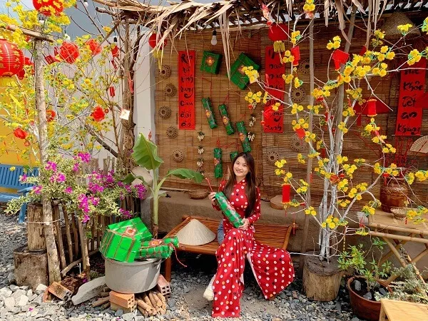 Có một người phụ nữ mặc váy đỏ và trắng ngồi trên băng ghế