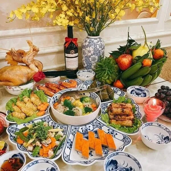 Có nhiều đĩa thức ăn trên bàn với một bình hoa