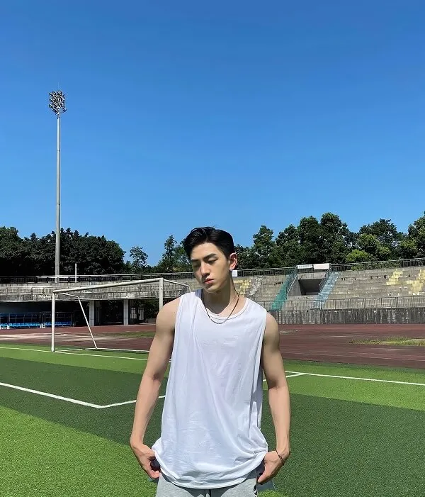 Cool ngầu ảnh trai đẹp che mặt chàng trẻ không áo đứng trên sân bóng đá với hai tay trong túi