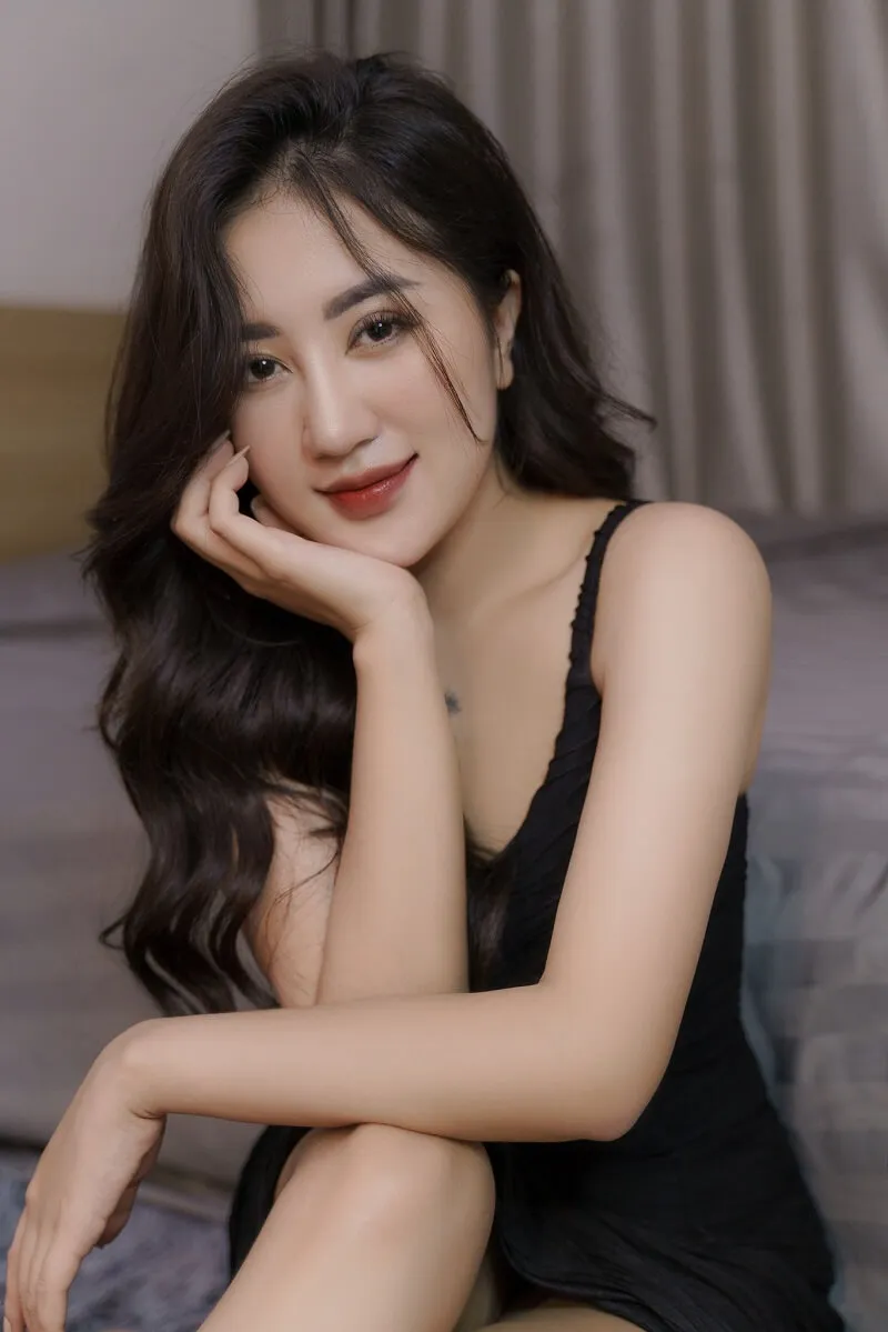 Dáng chụp ảnh tết có một người phụ nữ đang ngồi trên giường tạo cho bức tranh