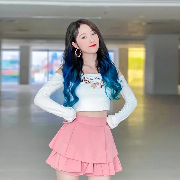 Đào lê phương hoa tiktok có một người phụ nữ đang đứng trong căn phòng với mái tóc xanh