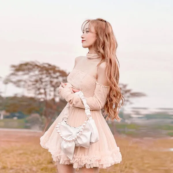 Đào lê phương hoa tiktok có một người phụ nữ đang đứng trên cánh đồng với chiếc ví