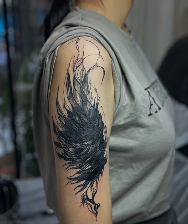 Có một người phụ nữ hình xăm con chim đen trên cánh tay của cô ấy