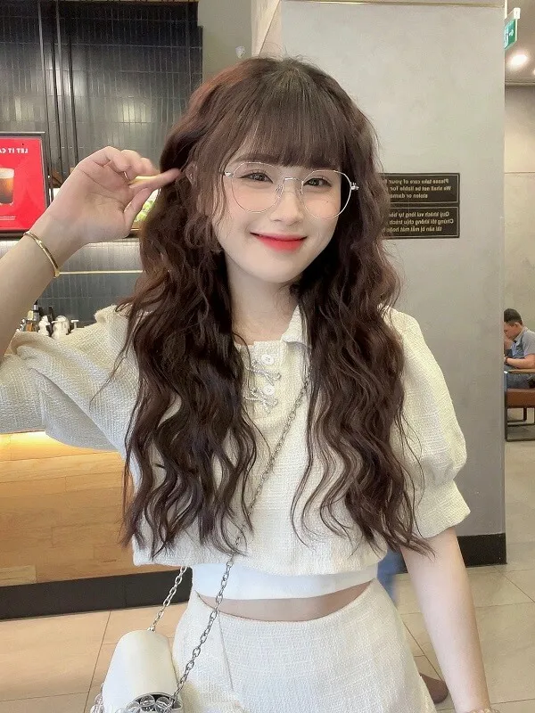 Gái xinh tóc dài đeo kính có một người phụ nữ mái và tạo dáng cho bức tranh