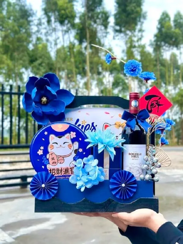 Giỏ quà tết đơn giản có một người cầm hộp hoa và chai rượu