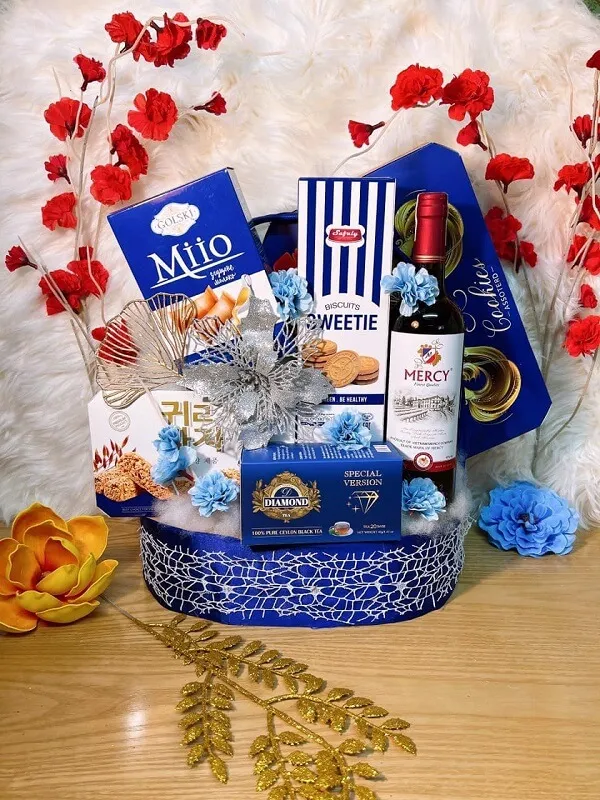 Giỏ quà tết kỳ nghỉ đỏ trắng và xanh với rượu bánh quy kẹo