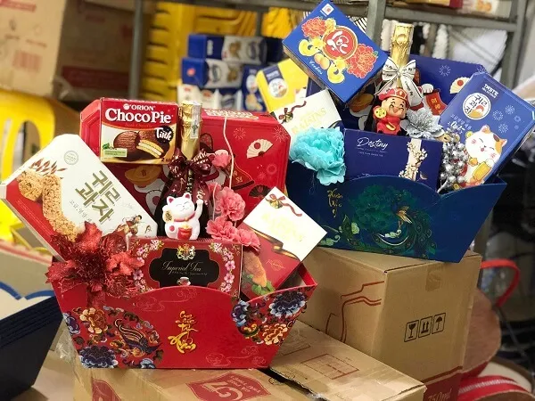 Giỏ quà tết có một hộp sôcôla và kẹo trên bàn