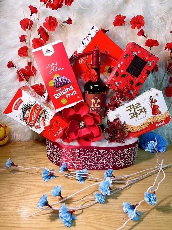 Giỏ quà tết có một màu đỏ và trắng chứa đầy các món ăn kẹo