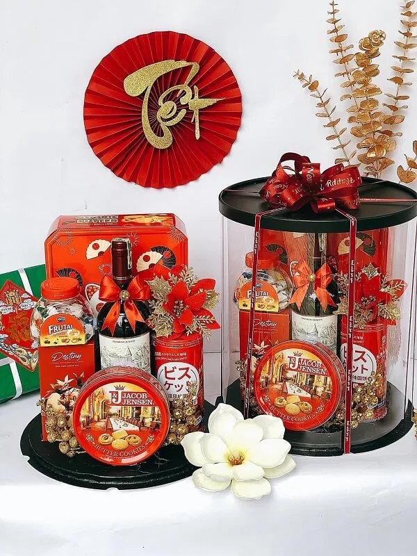 Giỏ quà tết trang trí năm mới của trung quốc được hiển thị trên một chiếc bàn trắng với quạt màu đỏ