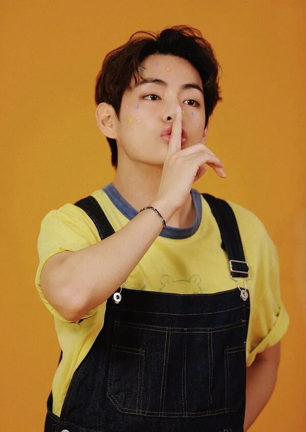 Ảnh bts có một chàng trai trẻ mặc áo liền quần và sơ mi màu vàng