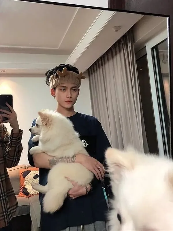 Ảnh trai đẹp cute có một người đàn ông đang ôm con chó trong vòng tay