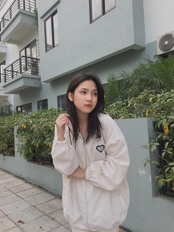 Hình ảnh gái xinh 2k5 có một người phụ nữ đang đứng trước tòa nhà
