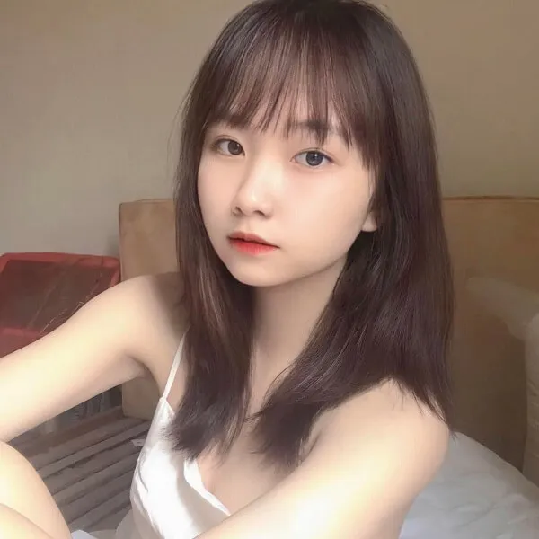 Hình ảnh gái xinh 2k5 có một người phụ nữ đang ngồi trên giường tạo dáng cho bức tranh