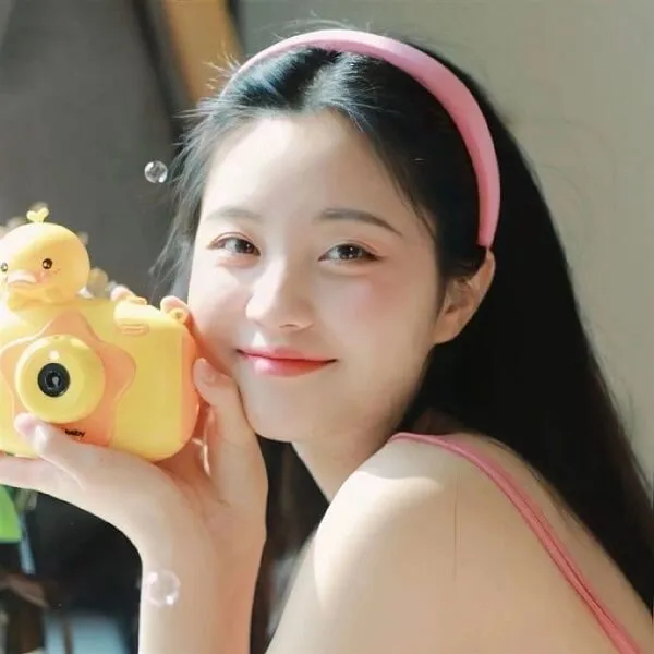 Hình ảnh gái xinh che mặt có một phụ nữ trẻ chụp với chiếc máy màu vàng