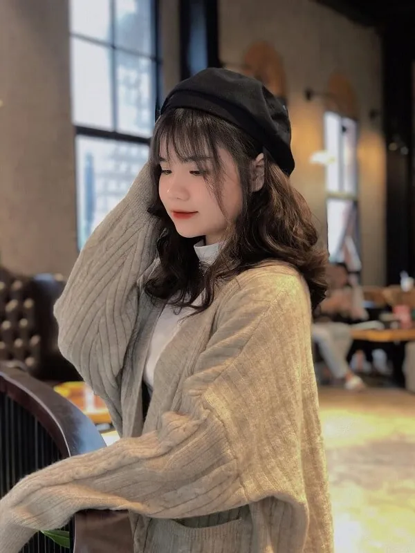 Ảnh 2k5 người phụ nữ đang mặc một chiếc áo len dài và mũ đen