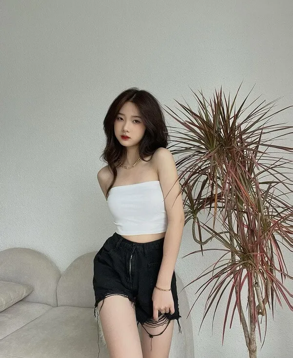 Ảnh gái xinh việt nam có một người phụ nữ đứng cạnh cái cây trong phòng khách