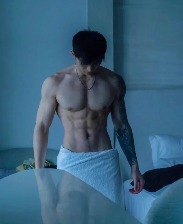 Hình ảnh hot boy đẹp trai có một người đàn ông không mặc áo đứng cạnh giường trong phòng