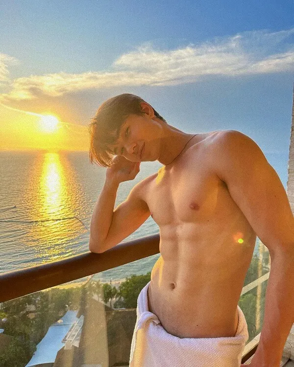 Hình ảnh hot boy đẹp trai có một người đàn ông đang đứng trên ban công với chiếc khăn